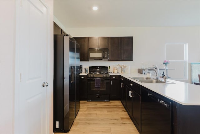 504 N Thunderstorm Ave, Lockhart, TX 78644 - kitchen featuring black appliances, light wood-style flooring, a peninsula, light countertops, and dark brown cabinets