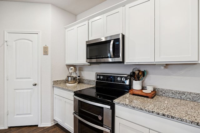 1004 Norway, Seguin, TX 78155 - kitchen with stainless steel appliances, white cabinetry, light stone counters, and dark wood-style floors
