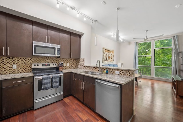 1320 Robert Browning St Unit 208, Austin, TX 78723 - kitchen featuring appliances with stainless steel finishes, a peninsula, dark wood-style floors, and dark brown cabinets
