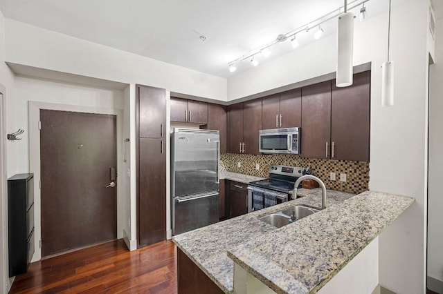 1320 Robert Browning St Unit 208, Austin, TX 78723 - kitchen featuring stainless steel appliances, a peninsula, dark wood-type flooring, dark brown cabinets, and light stone counters