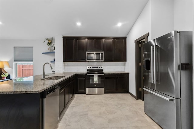 296 Blooming Trl, Kyle, TX 78640 - kitchen with appliances with stainless steel finishes, stone counters, a peninsula, decorative backsplash, and recessed lighting