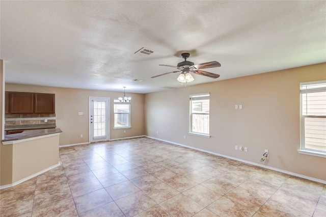 9104 Single Bend Trl, Temple, TX 76502 - unfurnished living room with a chandelier, a ceiling fan, light tile patterned floors, and a textured ceiling