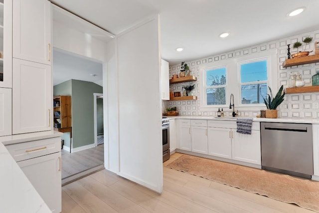 215 Paulus St, Schulenburg, TX 78956 - kitchen featuring stainless steel appliances, open shelves, decorative backsplash, light countertops, and white cabinetry