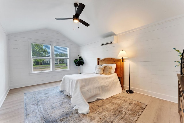 215 Paulus St, Schulenburg, TX 78956 - bedroom featuring an AC wall unit, light wood-style flooring, lofted ceiling, and ceiling fan