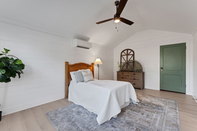 215 Paulus St, Schulenburg, TX 78956 - bedroom featuring a wall unit AC, lofted ceiling, wood finished floors, wooden walls, and ceiling fan