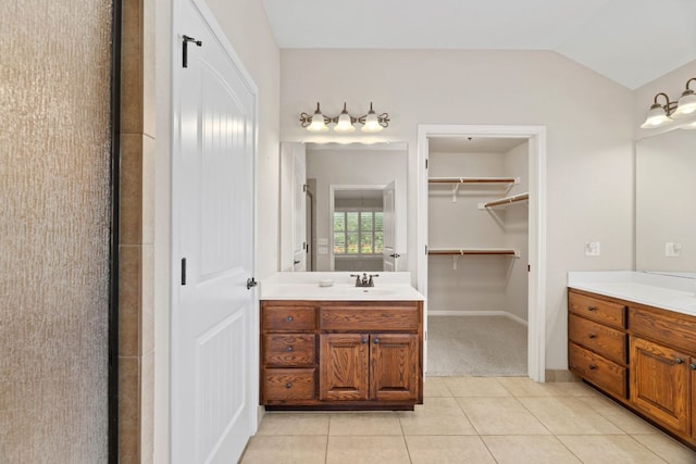 1403 Adam Ave, Burnet, TX 78611 - bathroom with two vanities, tile patterned floors, and vaulted ceiling