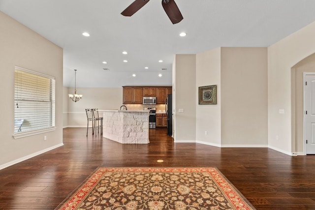 1403 Adam Ave, Burnet, TX 78611 - unfurnished living room featuring ceiling fan, dark wood finished floors, a chandelier, recessed lighting, and arched walkways