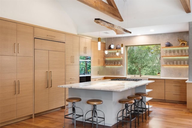 601 Crystal Creek Dr, Austin, TX 78746 - kitchen with paneled built in fridge, open shelves, a breakfast bar, stainless steel gas cooktop, and high vaulted ceiling