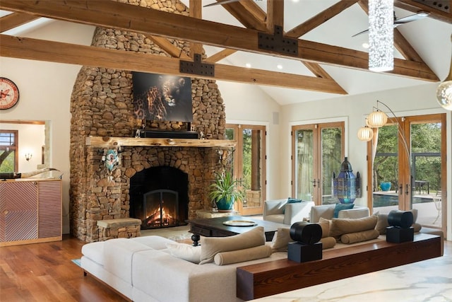 601 Crystal Creek Dr, Austin, TX 78746 - living area featuring french doors, beamed ceiling, high vaulted ceiling, a stone fireplace, and wood finished floors