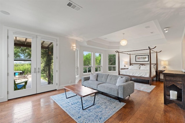 601 Crystal Creek Dr, Austin, TX 78746 - bedroom featuring access to outside, a tray ceiling, french doors, and hardwood / wood-style floors
