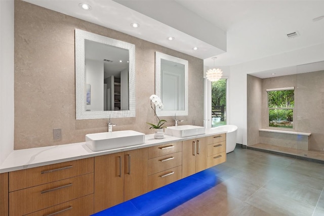 601 Crystal Creek Dr, Austin, TX 78746 - full bathroom with double vanity, tile walls, a freestanding bath, and recessed lighting