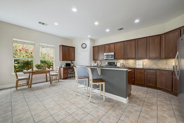 250 Lexington Dr, Austin, TX 78737 - kitchen with appliances with stainless steel finishes, tasteful backsplash, a center island, light tile patterned floors, and recessed lighting
