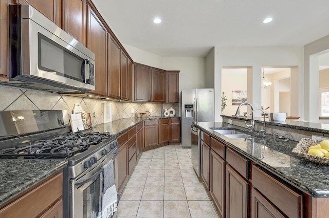 250 Lexington Dr, Austin, TX 78737 - kitchen featuring appliances with stainless steel finishes, tasteful backsplash, dark stone counters, recessed lighting, and a chandelier