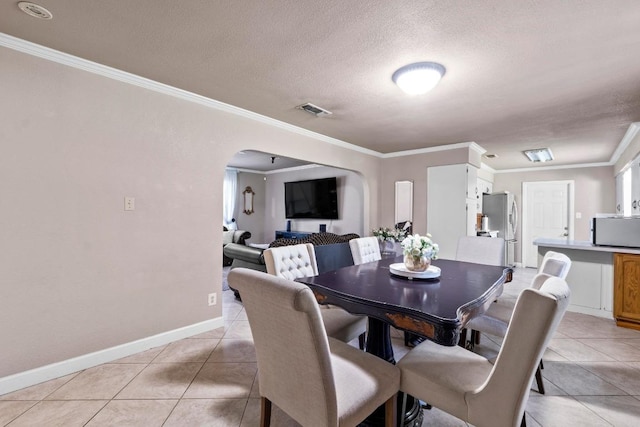 11907 Oak Trl, Austin, TX 78753 - dining area with arched walkways, light tile patterned floors, crown molding, and a textured ceiling