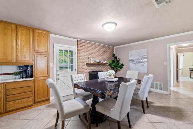11907 Oak Trl, Austin, TX 78753 - dining room with light tile patterned floors, ornamental molding, a textured ceiling, and a fireplace