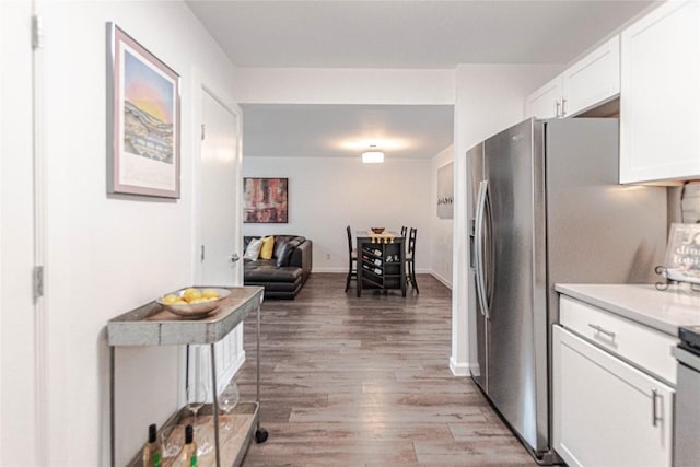 3604 Clawson Rd Unit 204, Austin, TX 78704 - kitchen with light wood-style flooring, white cabinets, light countertops, and stainless steel refrigerator with ice dispenser