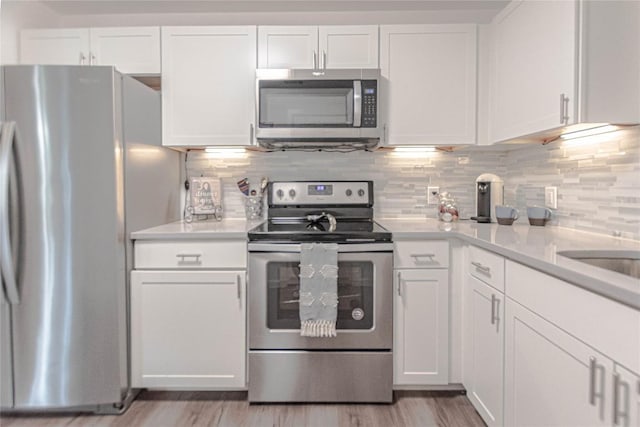 3604 Clawson Rd Unit 204, Austin, TX 78704 - kitchen featuring appliances with stainless steel finishes, white cabinets, light countertops, and tasteful backsplash