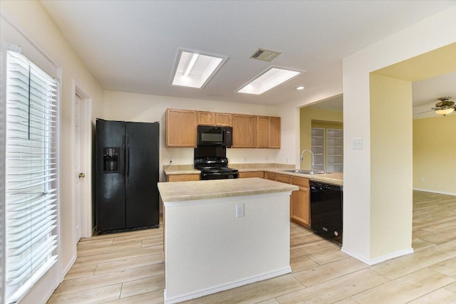 210 Deercreek Ln, Leander, TX 78641 - kitchen featuring black appliances, light countertops, light wood-style floors, and a kitchen island
