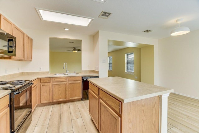 210 Deercreek Ln, Leander, TX 78641 - kitchen with black appliances, light wood finished floors, light countertops, a center island, and recessed lighting