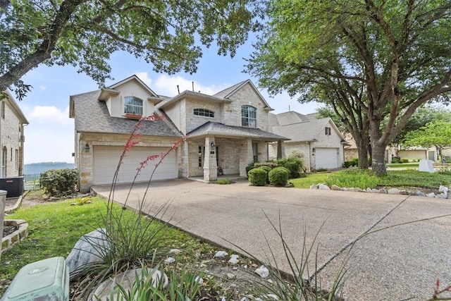 5724 Brittlyns Ct, Austin, TX 78730 - view of front of home with stone siding, driveway, a garage, covered porch, and a shingled roof