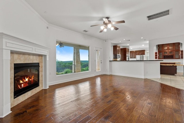 5724 Brittlyns Ct, Austin, TX 78730 - unfurnished living room featuring light wood-style floors, a ceiling fan, a tile fireplace, ornamental molding, and recessed lighting