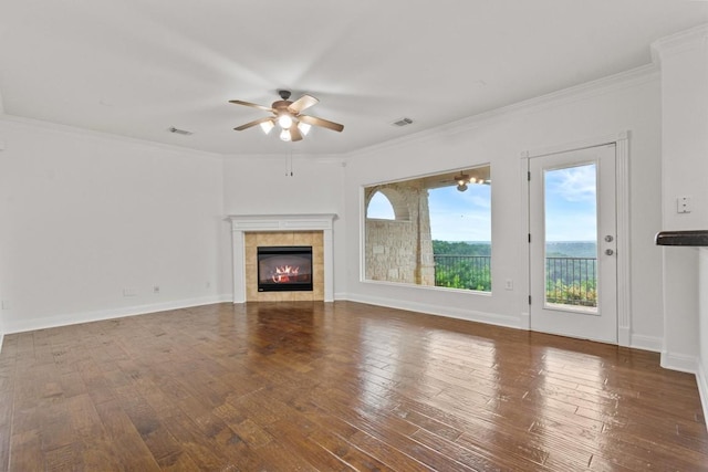 5724 Brittlyns Ct, Austin, TX 78730 - unfurnished living room featuring a ceiling fan, a tiled fireplace, hardwood / wood-style floors, and crown molding