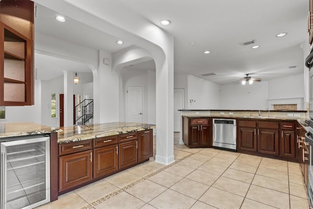 5724 Brittlyns Ct, Austin, TX 78730 - kitchen featuring beverage cooler, dishwasher, ceiling fan, arched walkways, and light stone counters