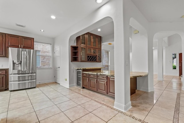 5724 Brittlyns Ct, Austin, TX 78730 - kitchen featuring stainless steel fridge, light tile patterned flooring, arched walkways, and recessed lighting