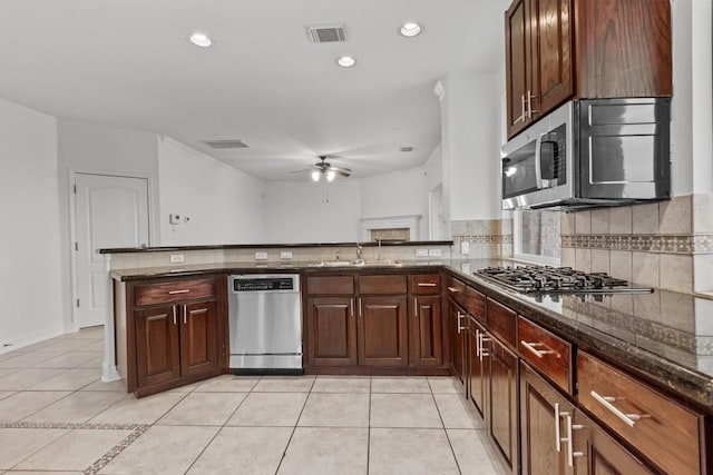 5724 Brittlyns Ct, Austin, TX 78730 - kitchen with appliances with stainless steel finishes, a ceiling fan, light tile patterned flooring, decorative backsplash, and recessed lighting