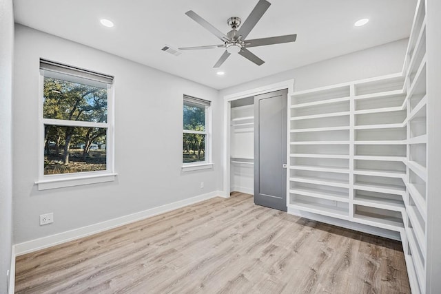 21603 Thomas Cv, Lago Vista, TX 78645 - unfurnished bedroom with multiple windows, wood finished floors, recessed lighting, a ceiling fan, and a closet