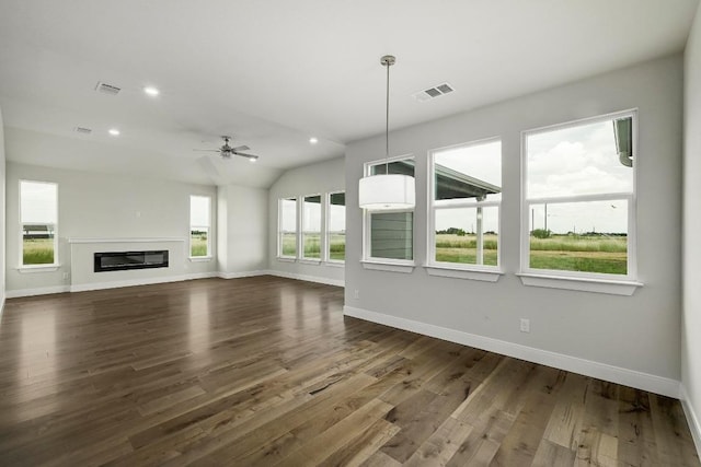 182 Alonzo Dr, Del Valle, TX 78617 - unfurnished living room with dark wood-style flooring, ceiling fan, recessed lighting, lofted ceiling, and a glass covered fireplace