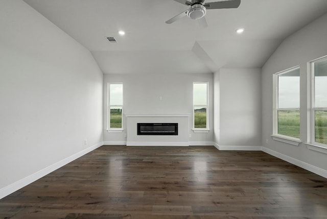 182 Alonzo Dr, Del Valle, TX 78617 - unfurnished living room with vaulted ceiling, plenty of natural light, dark wood-type flooring, a glass covered fireplace, and a ceiling fan