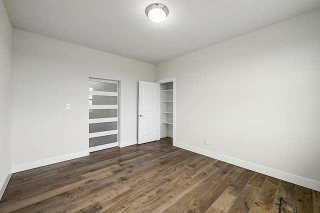182 Alonzo Dr, Del Valle, TX 78617 - unfurnished bedroom with dark wood finished floors and baseboards