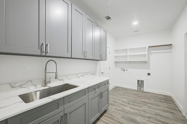182 Alonzo Dr, Del Valle, TX 78617 - laundry area featuring cabinet space, hookup for an electric dryer, washer hookup, and light wood finished floors