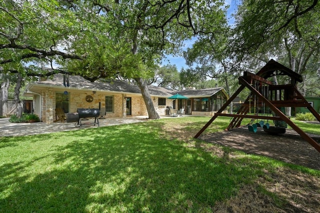 11001 Spicewood Club Dr, Austin, TX 78750 - rear view of property featuring stone siding, a playground, a lawn, a patio, and heating fuel