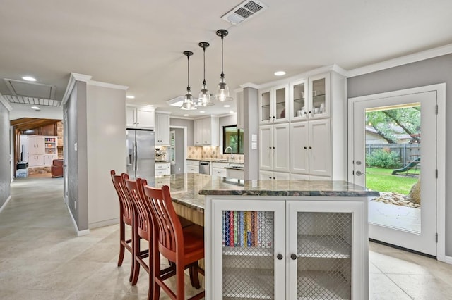 11001 Spicewood Club Dr, Austin, TX 78750 - kitchen featuring crown molding, appliances with stainless steel finishes, decorative backsplash, glass insert cabinets, and white cabinets