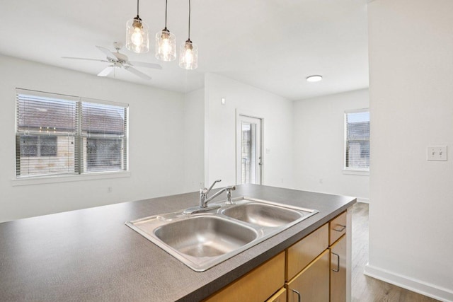 1201 Grove Blvd Unit 1502, Austin, TX 78741 - kitchen featuring dark countertops, ceiling fan, wood finished floors, and pendant lighting