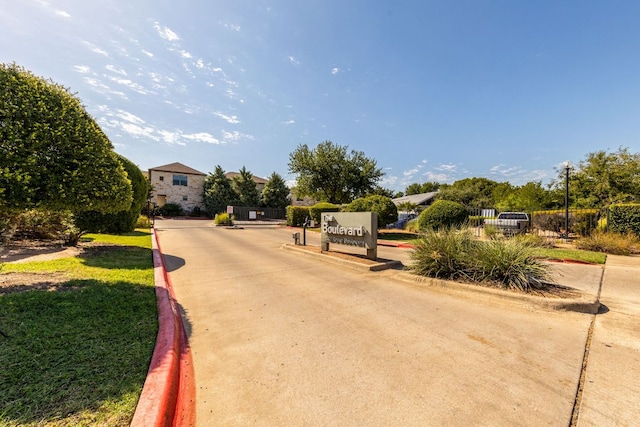 1201 Grove Blvd Unit 1502, Austin, TX 78741 - view of concrete road with curbs, a gated entry, and street lighting