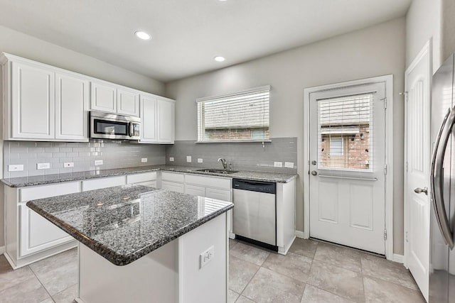 513 Heinatz Flat Ln, Leander, TX 78641 - kitchen with stainless steel appliances, tasteful backsplash, white cabinets, dark stone counters, and recessed lighting