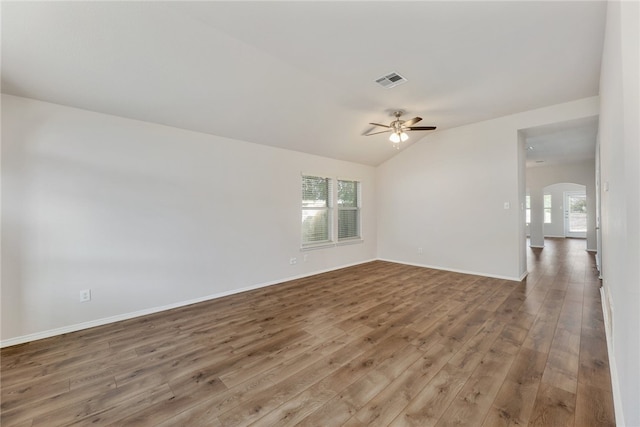 14400 Mowsbury Dr, Austin, TX 78717 - empty room with arched walkways, wood finished floors, plenty of natural light, a ceiling fan, and vaulted ceiling