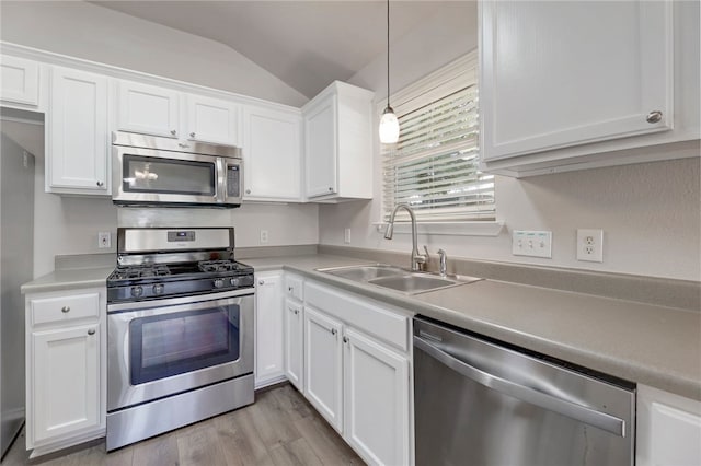14400 Mowsbury Dr, Austin, TX 78717 - kitchen featuring stainless steel appliances, vaulted ceiling, white cabinetry, light wood-style floors, and light countertops