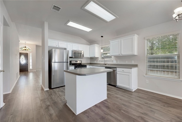 14400 Mowsbury Dr, Austin, TX 78717 - kitchen with stainless steel appliances, dark wood finished floors, lofted ceiling, white cabinets, and a center island