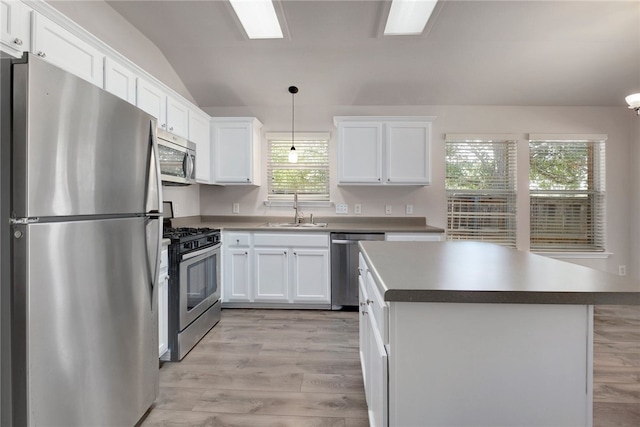 14400 Mowsbury Dr, Austin, TX 78717 - kitchen featuring stainless steel appliances, vaulted ceiling, white cabinets, light wood-type flooring, and a center island