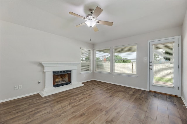14400 Mowsbury Dr, Austin, TX 78717 - unfurnished living room featuring healthy amount of natural light, wood finished floors, a ceiling fan, and a fireplace with raised hearth