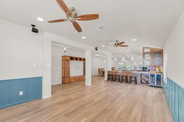 815 Clarence Bohls Ln, Pflugerville, TX 78660 - living area with ceiling fan, light wood-style floors, recessed lighting, wine cooler, and wainscoting