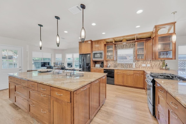 815 Clarence Bohls Ln, Pflugerville, TX 78660 - kitchen featuring black appliances, light wood-style flooring, decorative backsplash, light stone countertops, and recessed lighting