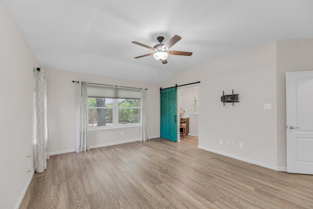 815 Clarence Bohls Ln, Pflugerville, TX 78660 - empty room featuring light wood-style flooring, ceiling fan, a barn door, and vaulted ceiling