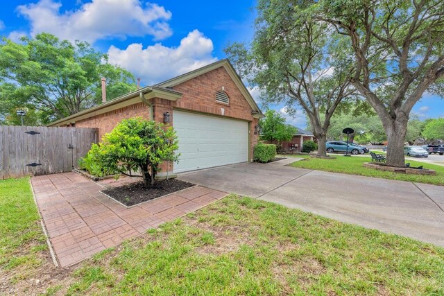 815 Clarence Bohls Ln, Pflugerville, TX 78660 - view of property exterior featuring a gate, driveway, a garage, and brick siding