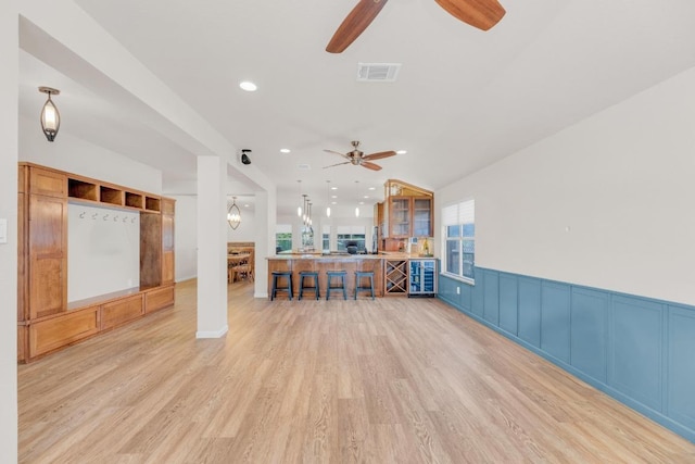 815 Clarence Bohls Ln, Pflugerville, TX 78660 - living area with wine cooler, a ceiling fan, light wood-type flooring, a wainscoted wall, and recessed lighting