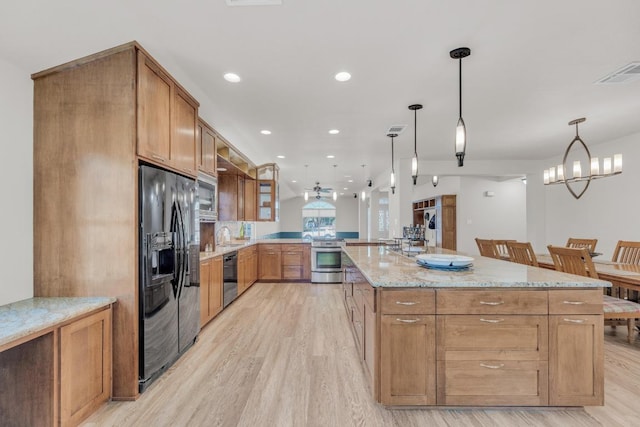 815 Clarence Bohls Ln, Pflugerville, TX 78660 - kitchen featuring black appliances, light wood-style floors, light stone counters, pendant lighting, and recessed lighting
